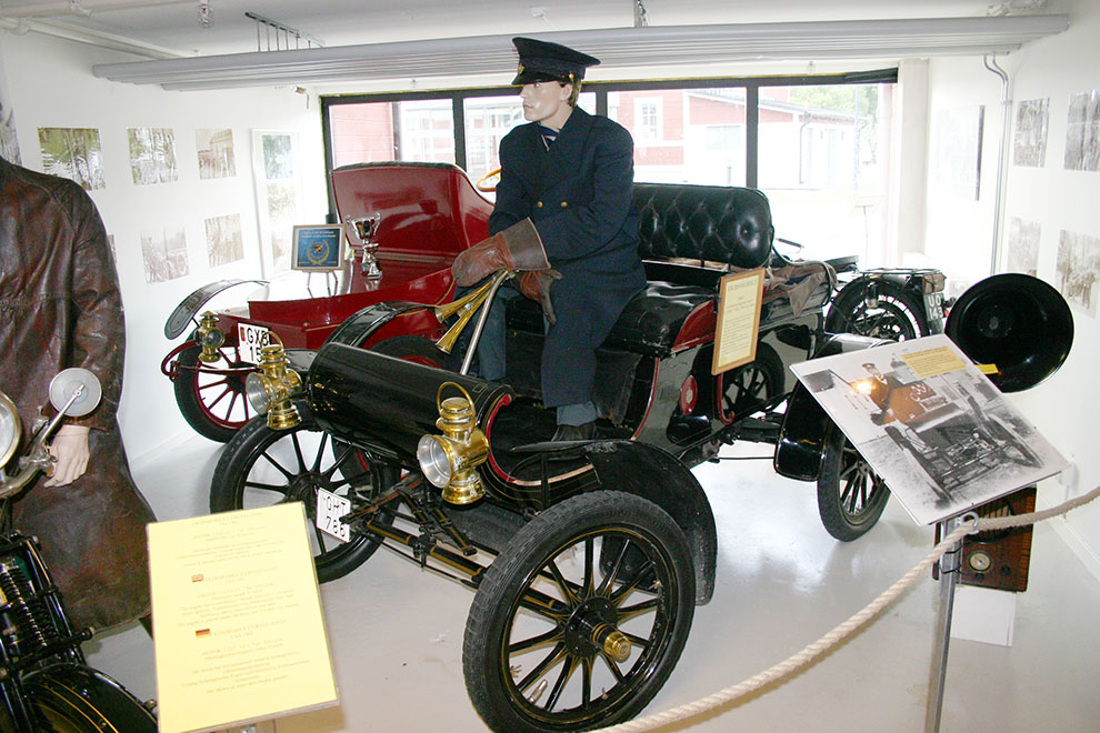 Den berömda Oldsmobile Curved Dash, här i 1905 års upplaga. På sin tid världens mest sålda bil! I bakgrunden en fin 1907 Cadillac Model K-M Runabout. En automobil som Motala Motormuseum förvärvade redan i september 1996.