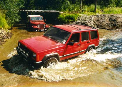 Jeep-möte i bäcken! En Jeep Cherokee gör en djupdykning på övningsfältet i Umeå 1999 medan besättningen i en Jeep CJ-5 tittar på. Ju längre norrut desto ljusare blir nätterna och norr om polcirkeln möter den unika midnattssolen!