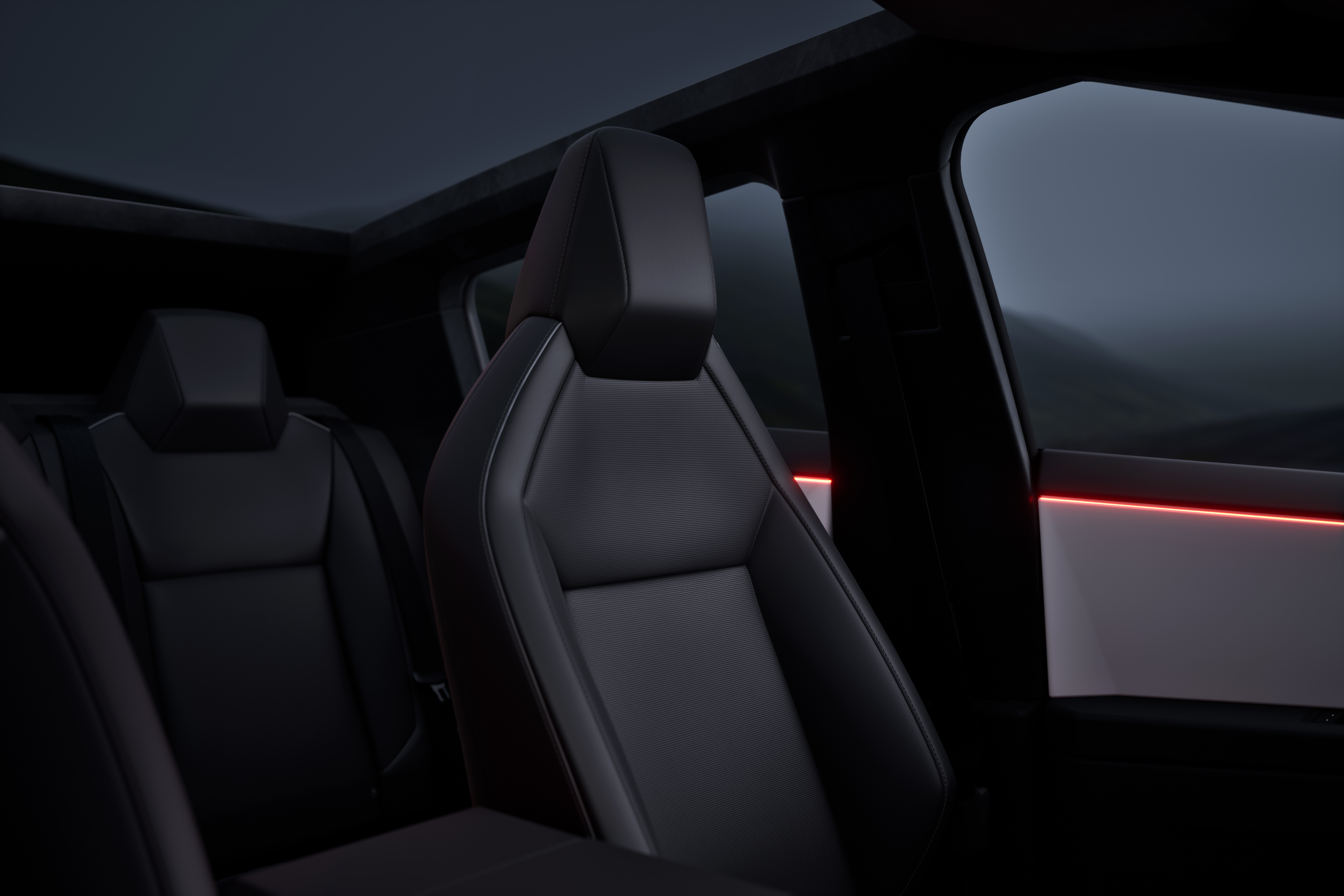 Mörk inredning i Tesla Cybertruck med två säten synliga och diskret röd ambientbelysning längs dörren.