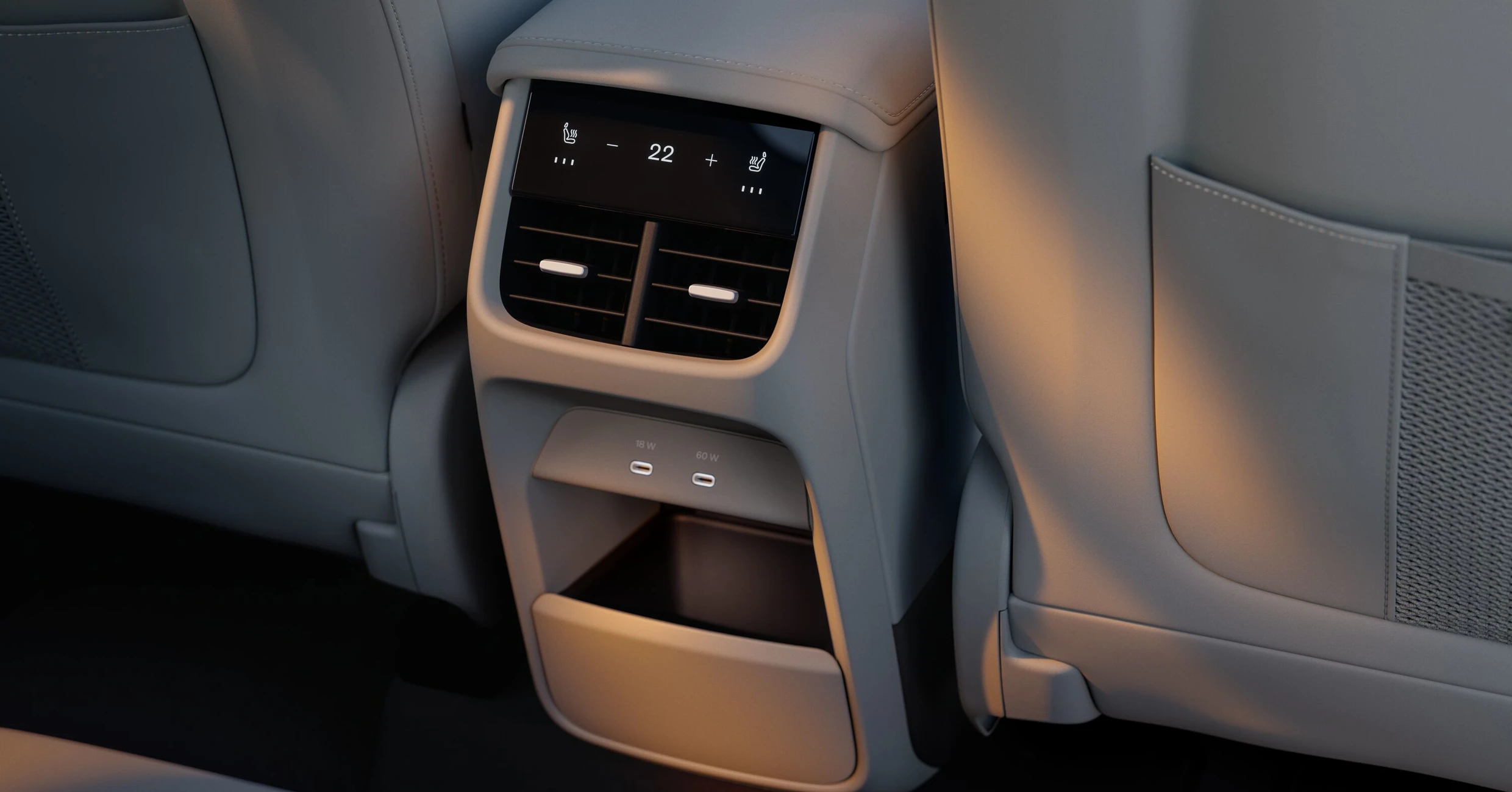 Interiördetalj av Volvo EX60: klimatkontroll med skärm, ventiler, USB-C-uttag och förvaringsfack mellan baksätena.