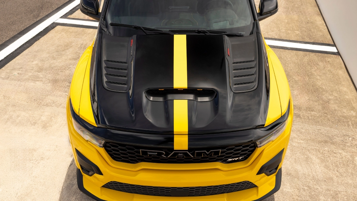 Den aggressiva fronten på Ram 1500 SRT TRX med det framträdande luftintaget och "RAM SRT"-märket i grillen under den svarta motorhuven med gul racingrand.