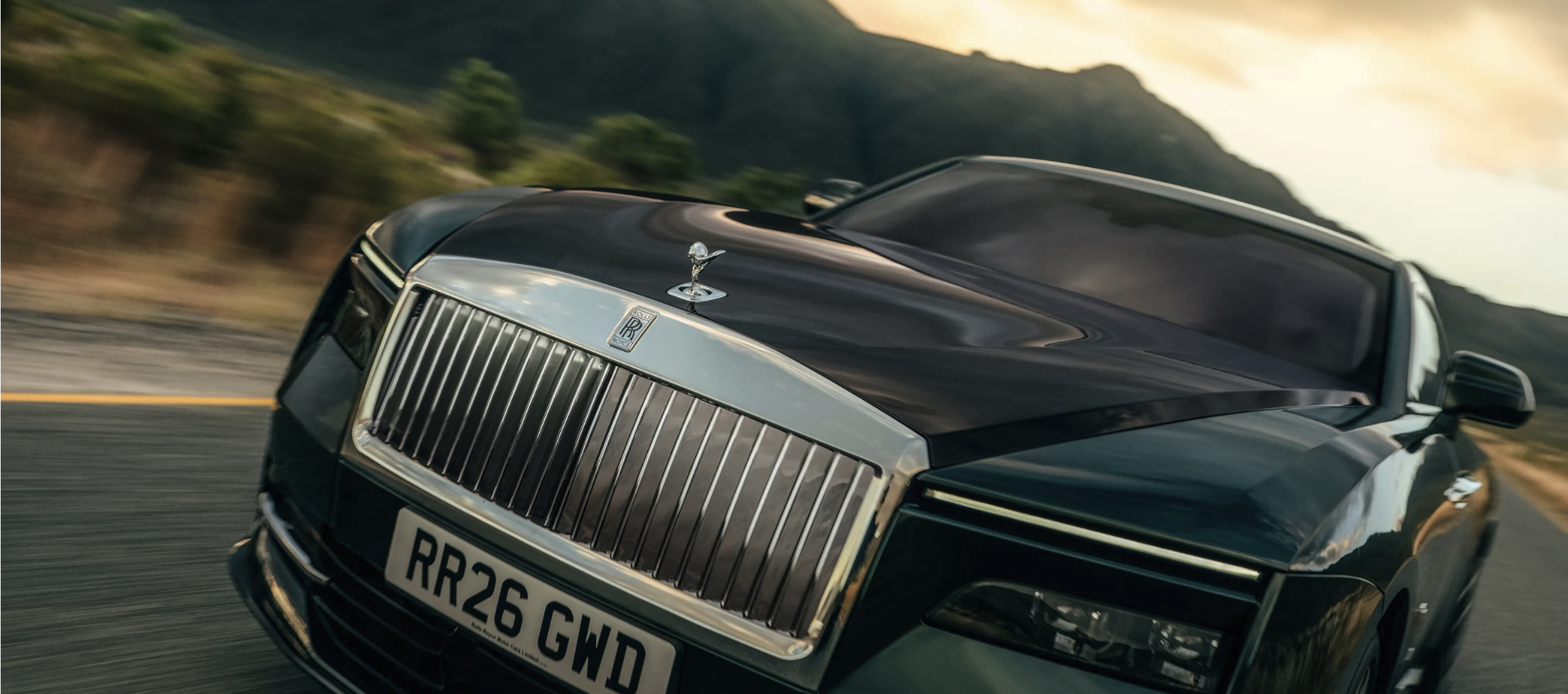 Rolls-Royce Spectre på vägarna, med bergen i bakgrunden. Ett klassiskt formspråk möter elektrisk framdrivning i denna lyxiga elbil.