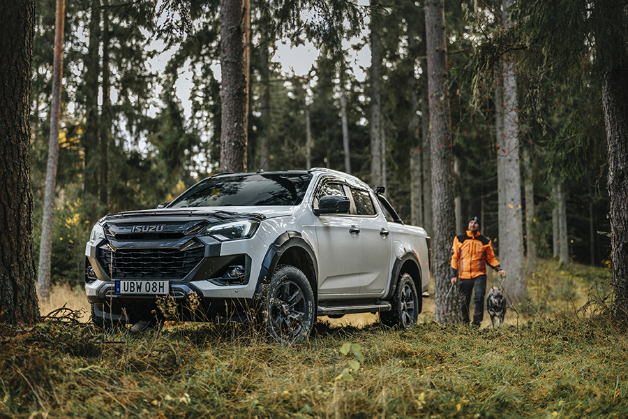 Isuzu D-Max ute i skogen med en förare och hund. Bilen är ett bra budgetalternativ bland "arbetshäst"-pickuperna.