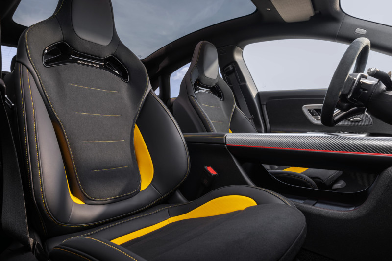 Interiören i en AMG CLA 45 e-motor med sportstolar, kolfiberpaneler och gula detaljer. Känslan av lyx och sportighet är tydlig.