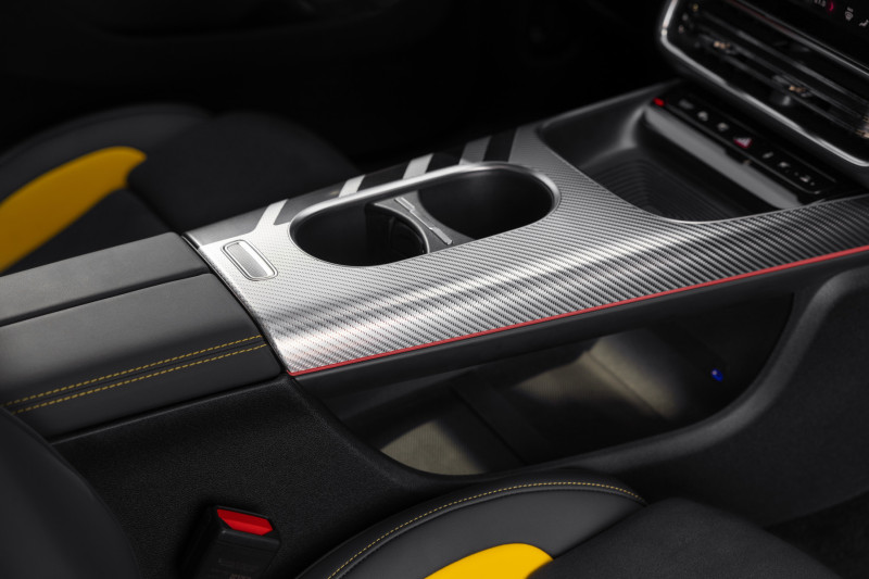 Interiören i nya eldrivna Mercedes-AMG CLA 45, med rött accentstreck och svart och silverfärgad kolfiberimitation.