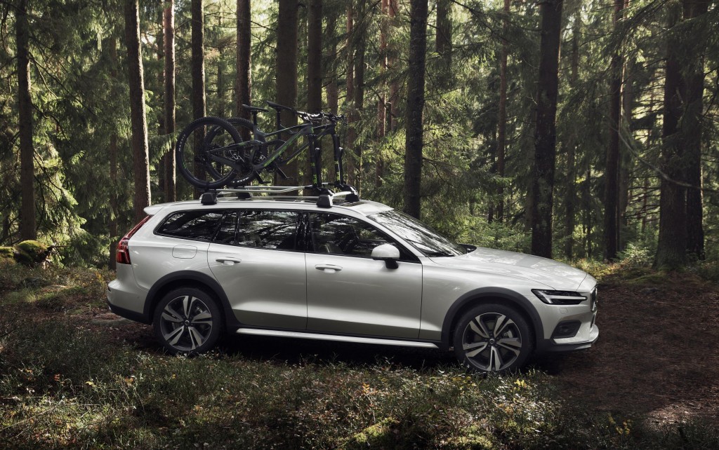 En Volvo V60 Cross Country med takräcke och cykel, parkerad i skogen. Ett attraktivt alternativ på begagnatmarknaden för den aktiva.