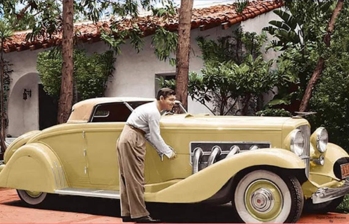 Clark Gable med sin JN Duesenberg 1935, färglagd bild. Notera att bilen är gul, inte den röda och silver JN han också ägde.