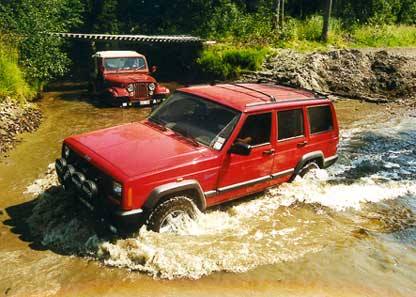 Jeep-möte i bäcken! En Jeep Cherokee gör en djupdykning på övningsfältet i Umeå 1999 medan besättningen i en Jeep CJ-5 tittar på. Ju längre norrut desto ljusare blir nätterna och norr om polcirkeln möter den unika midnattssolen!