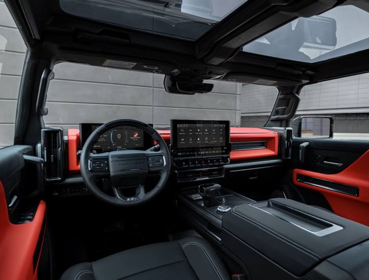 Interiören i Hummer EV SUV kombinerar robust design med moderna digitala skärmar och en exklusiv känsla, här med röda detaljer.