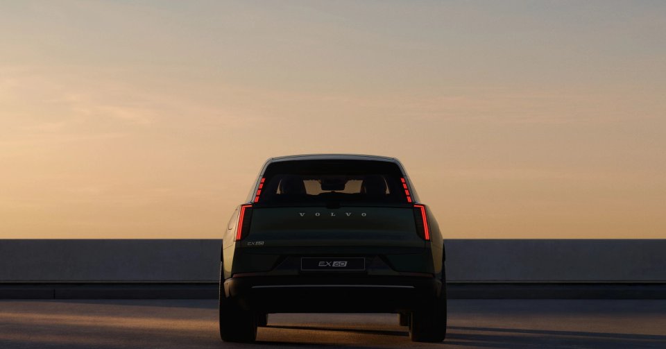 Volvo EX60:s design bakifrån med framträdande vertikala bakljus mot en varm kvällshimmel. En hint om framtida "Volvo"-design.