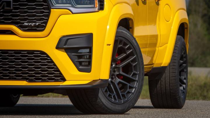 Den gula fronten av Ram TRX med SRT-märke, svarta fälgar med röda bromsok, parkerad på asfalt.