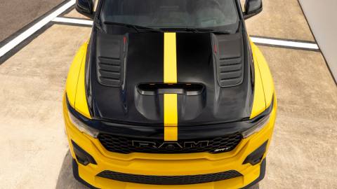 Den aggressiva fronten på Ram 1500 SRT TRX med det framträdande luftintaget och "RAM SRT"-märket i grillen under den svarta motorhuven med gul racingrand.