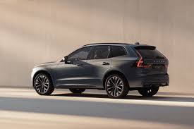 Den bakre delen och sidoprofilen av en mörkgrå Volvo XC60 mot en ljus vägg.