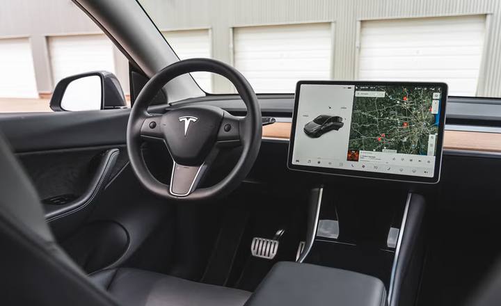 Interiören i en Tesla Model Y. Den stora skärmen är central för bilens funktioner och navigationssystem.
