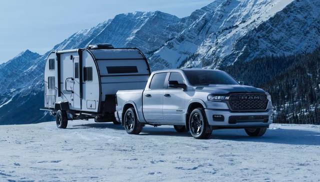 En Dodge Ram 1500 Black Edition drar en husvagn genom ett snöigt vinterlandskap. Black Edition utmärks av mörka detaljer exteriört.