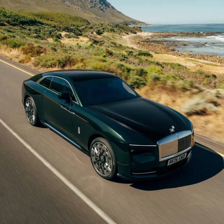 Rolls-Royce Spectre Series II tar sig fram längs en vacker kustväg, en elbil som behåller märkets klassiska estetik.
