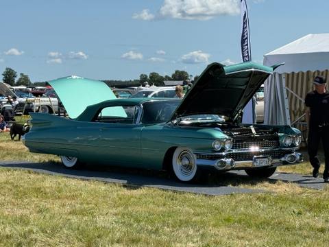En imponerande Cadillac cabriolet från slutet av 50-talet med öppen motorhuv och baklucka, redo för granskning på Big Swap Meet.